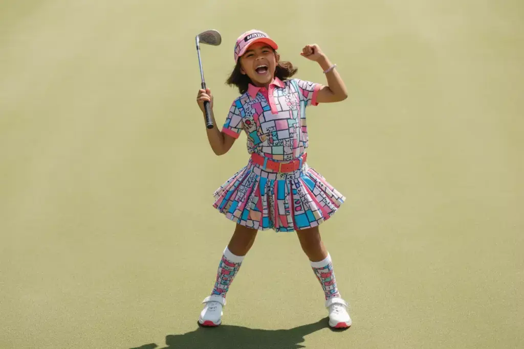 Fun And Funky Young Golfer In Bold Patterns And Bright Colors On Green