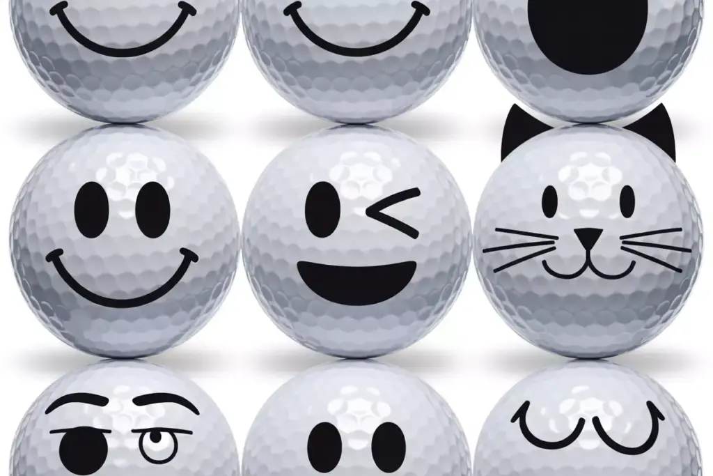 Flat lay of three golf balls with smiley wink and cat faces