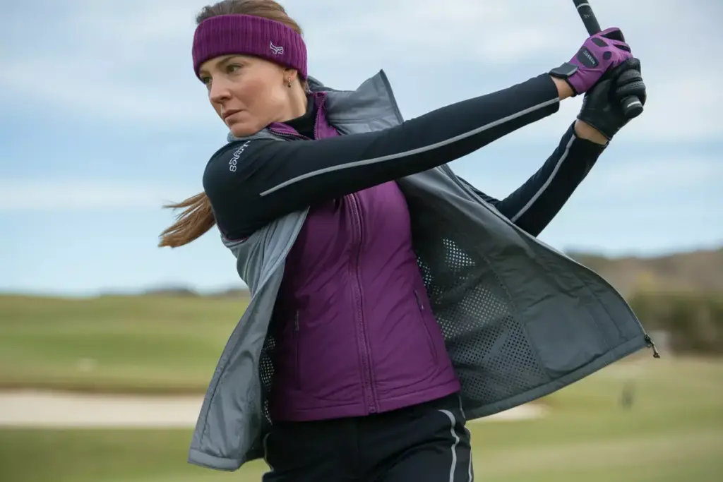 The Modern Athletic Ensemble Woman Golfer In Purple Vest Swinging On Course