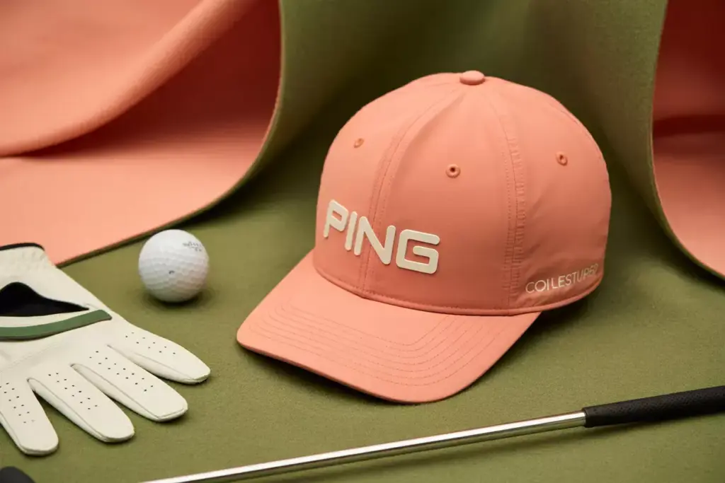 Ping coral pink structured cap flat lay golf accessories