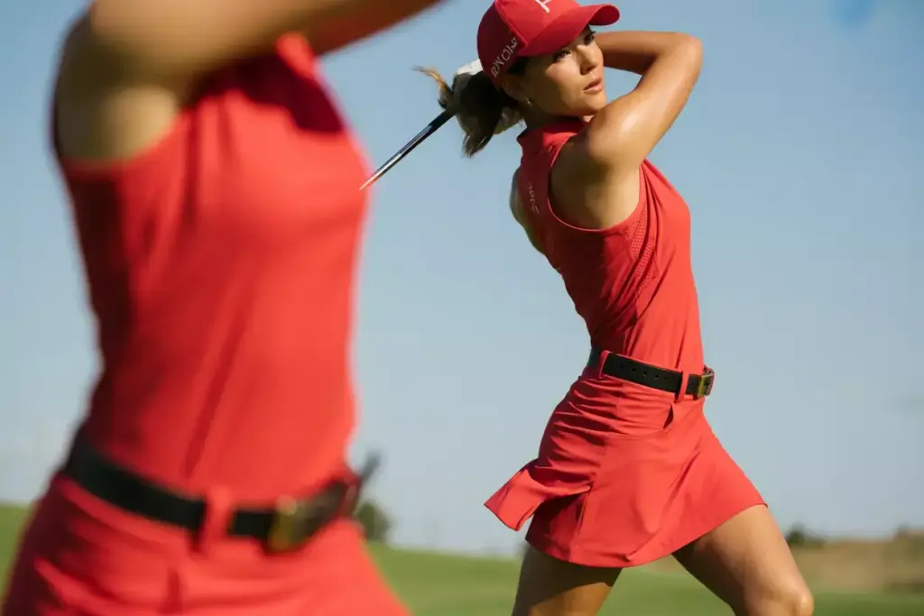 Sleeveless red racerback golf dress mid swing sunny fairway