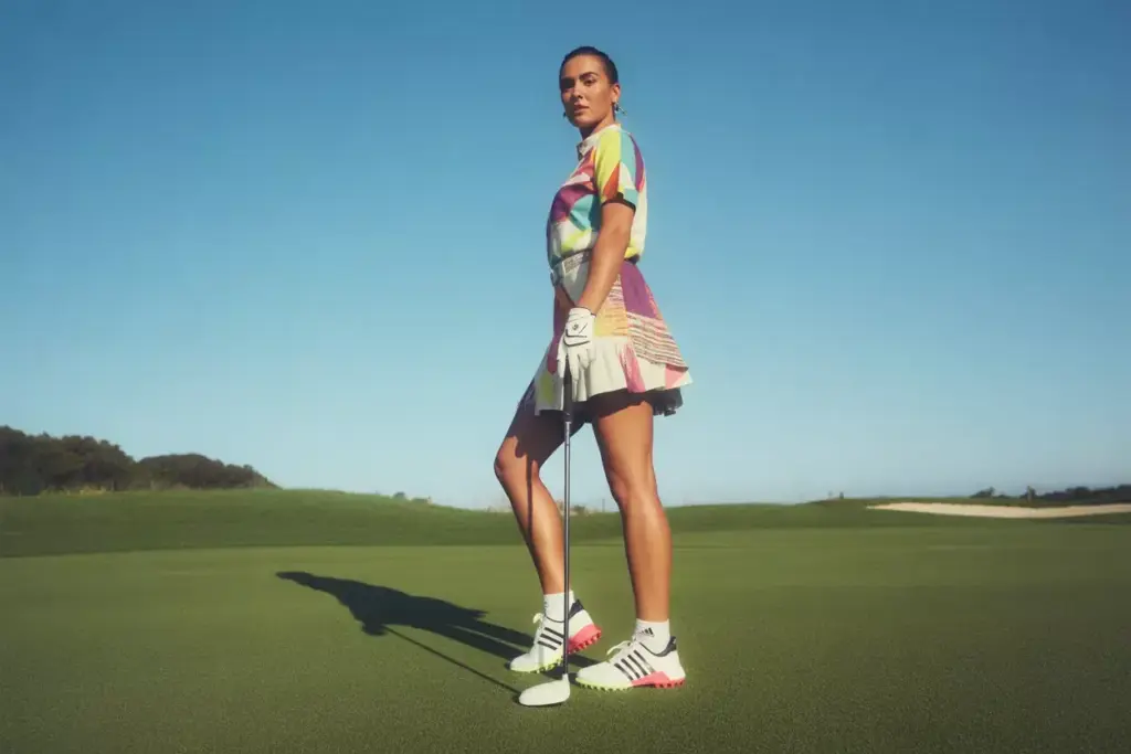 Stylish female golfer wearing bold colorful adidas codechaos shoes on fairway
