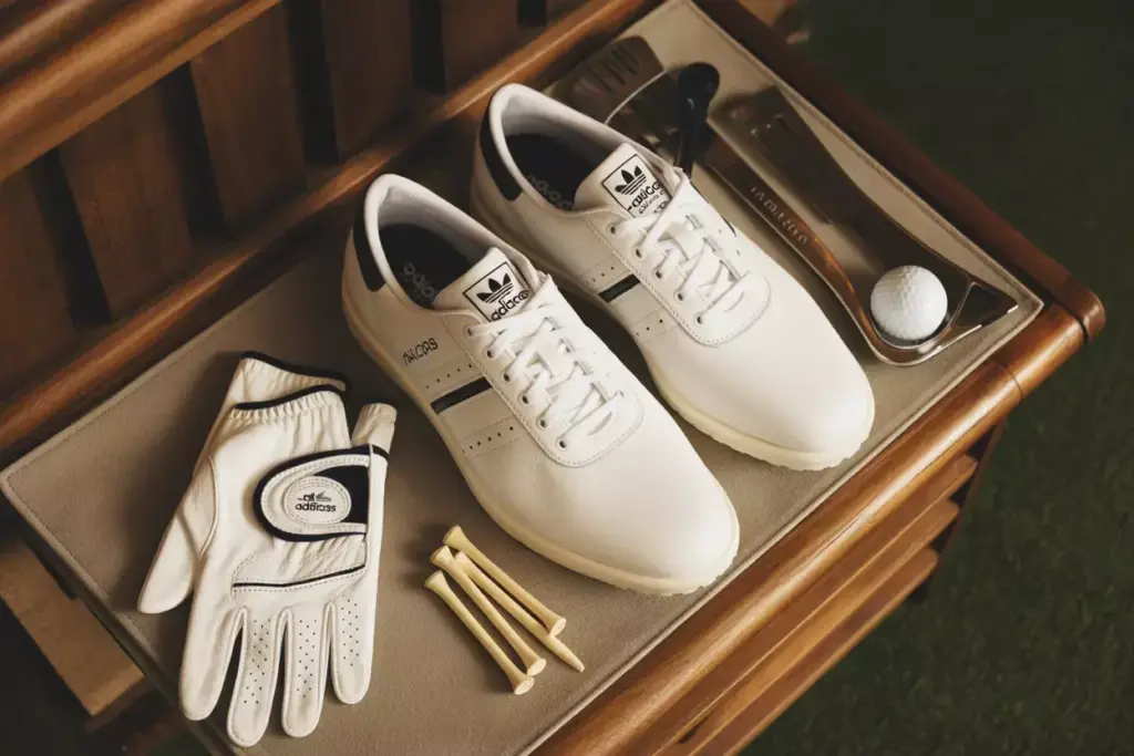 Classic white adidas adicross retro shoes with leather glove on wood bench