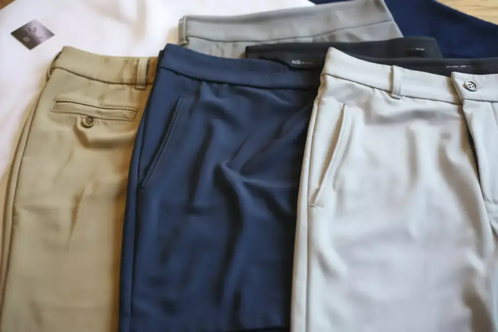 A Flat Lay Of Khaki Golf Shorts A Navy Skort And White Golf Pants