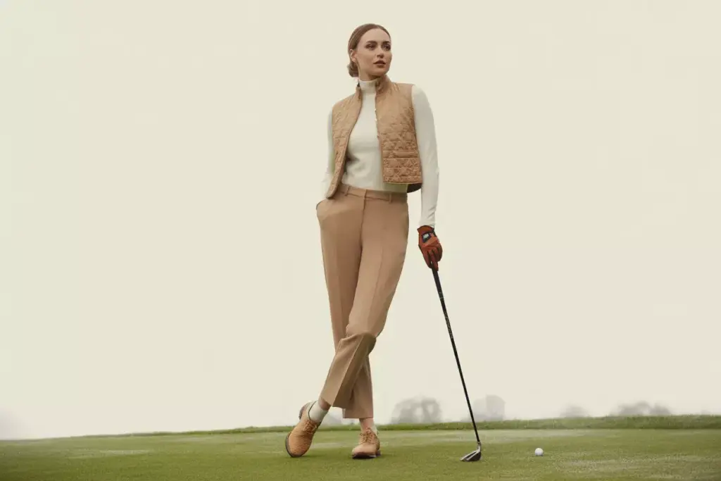 Woman polished neutral golf outfit camel trousers quilted vest