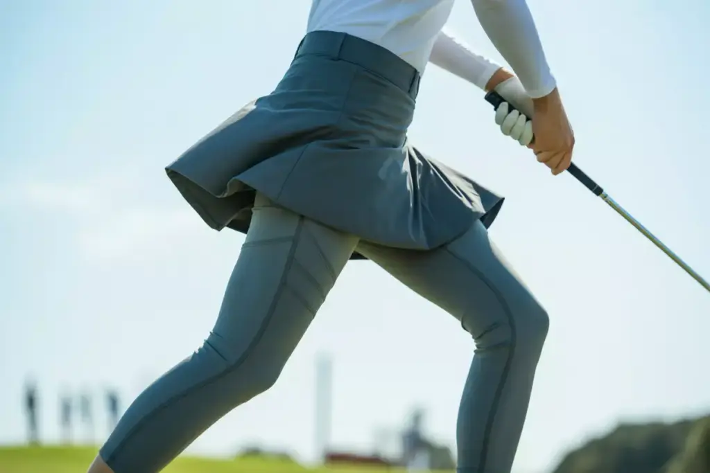 A line skirt with compression leggings during golf swing action