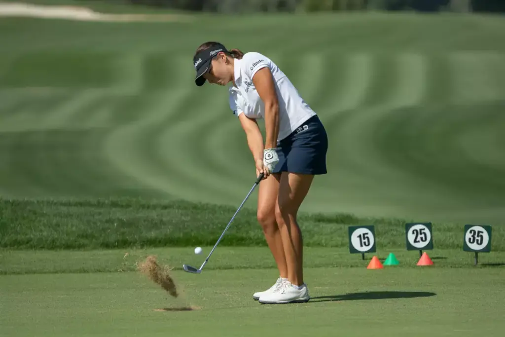 Female Golfer Executing Chip Shot With Proper Weight Forward Technique