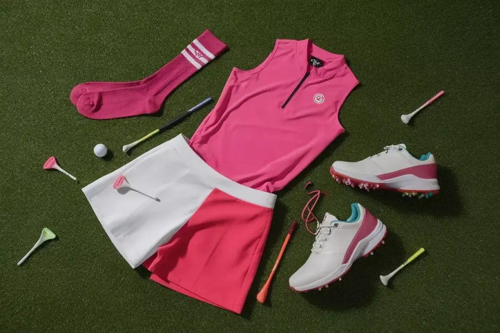 Bold fuchsia golf outfit components on green background