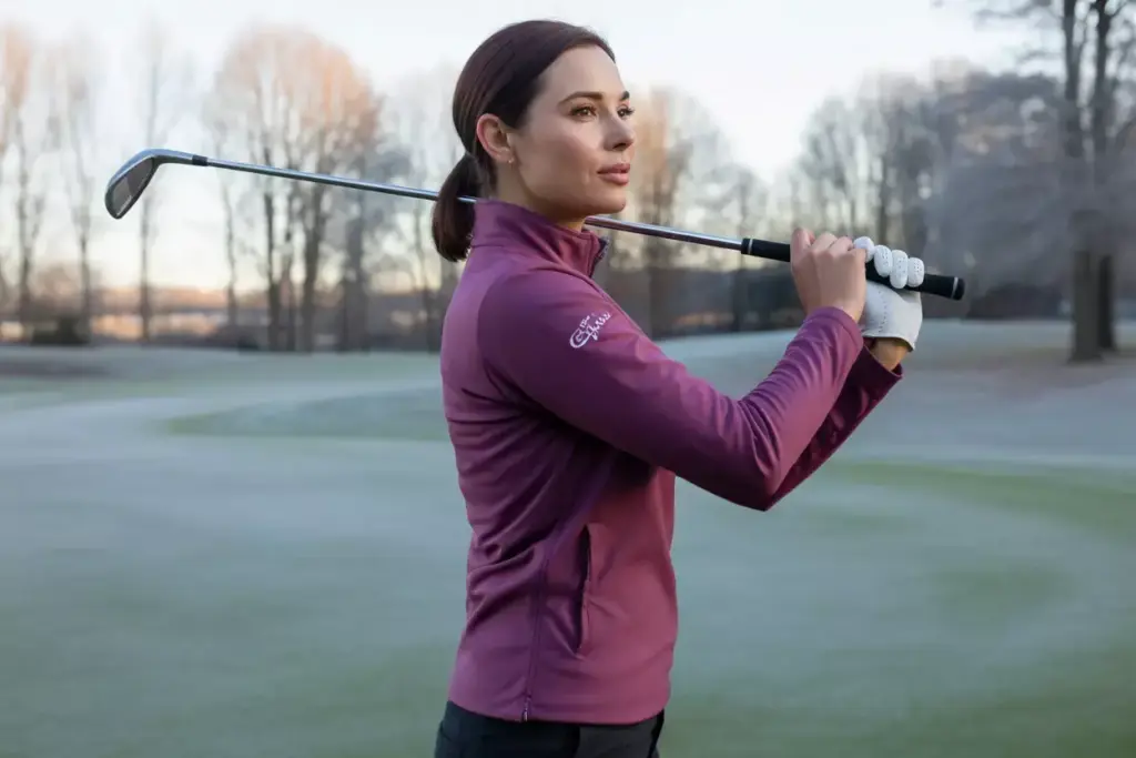 Woman golfer wearing fitted fleece mid layer on frosty fairway
