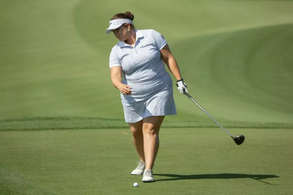 Plus size golfer classic polo skort swing on fairway
