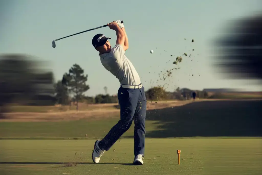 A Golfer In Mid Swing Action With A Blurred Club And Focused Athletic Form