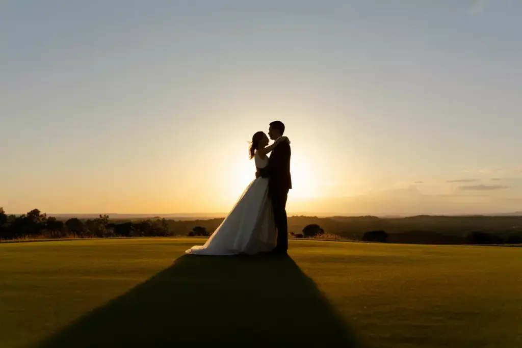 Sunset Silhouette Of Couple Embracing On Manicured 18th Green With Golden Hour Sky Backdrop