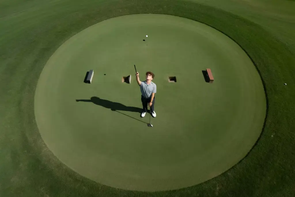 An Aerial Drone Shot Of A Golfer Standing On A Geometric Putting Green