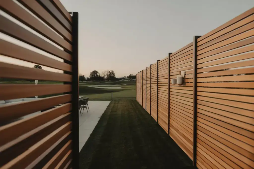 Modern Horizontal Slat Privacy Fence Bordering A Golf Course Patio