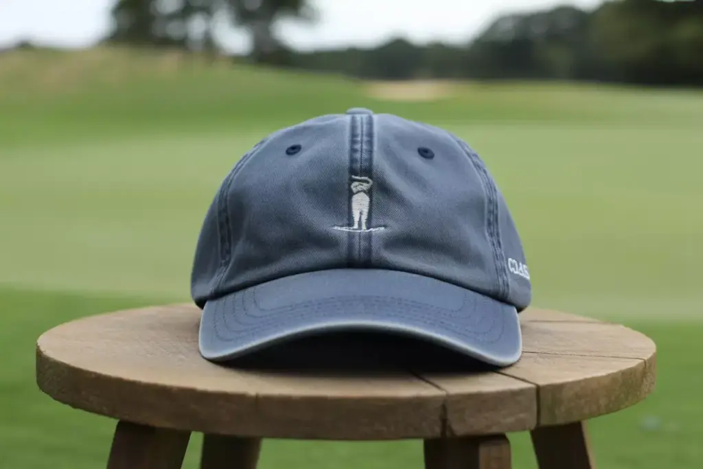 Navy Classic Golf Cap On Wood With Fairway Background