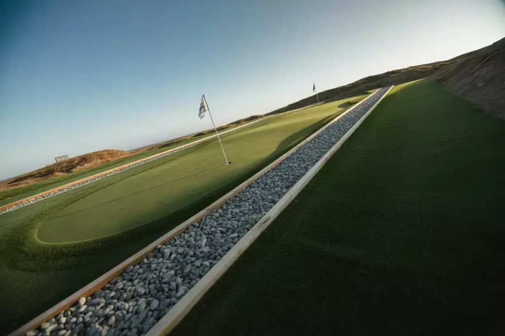 A Steep Uphill Putting Green With Gravel French Drain And Hole At The Crest