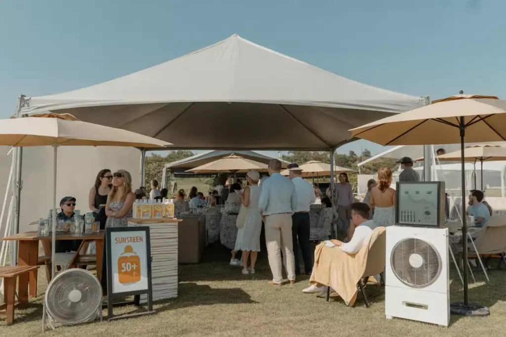 Outdoor Golf Party Under Large Event Tent With Market Umbrellas Sunscreen Station And Weather Monitor